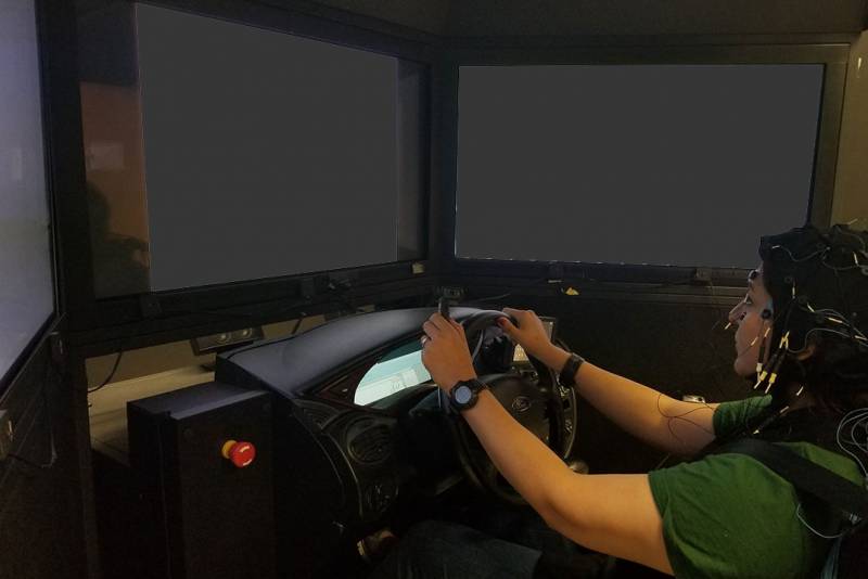 Photo of person using the driving simulator.